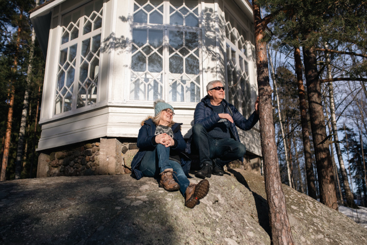 Pariskunta nauttimassa keväisestä säästä Fjällbon puiston huvimajan edustalla