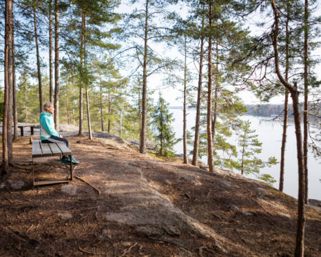 Nainen istuu penkillä Tuusulan Sarvikalliolla