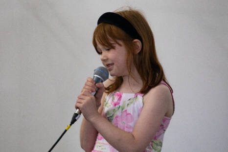 The girl is holding a microphone in her hand.