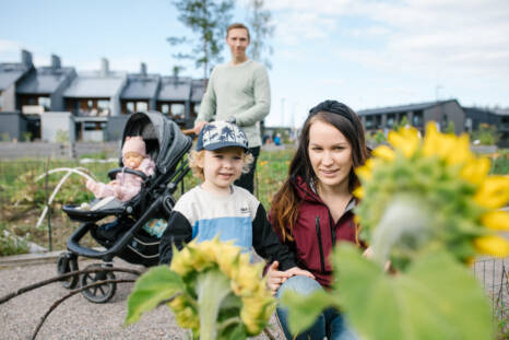 Perhe, jossa on kaksi lasta ja kaksi aikuista, on ulkoilemassa Puustellinmetsän puistossa.