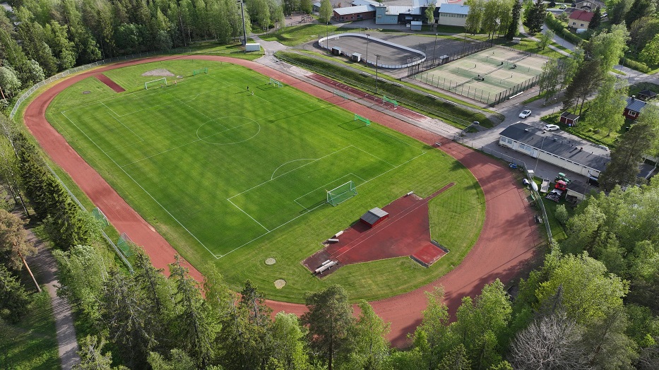 Jokelan urheilukeskuksen ilmakuvassa juoksurata jonka keskellä jalkapallokenttä. Tausatalla tenniskentät ja monikaukalo.