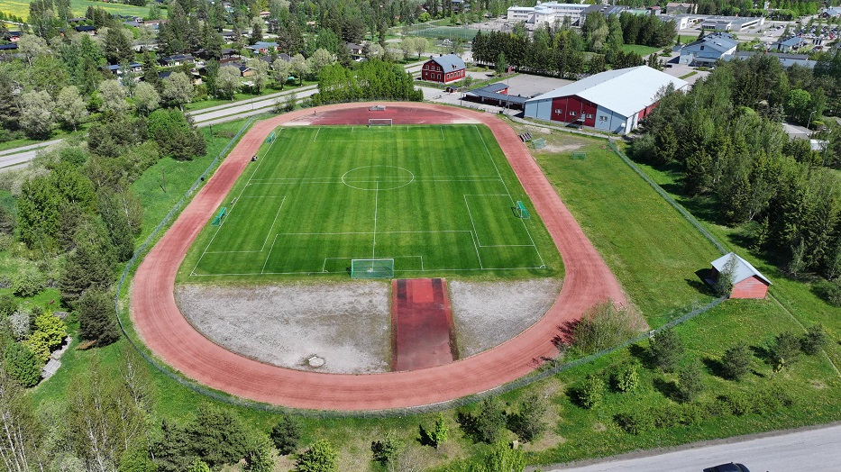 Kellokosken urheilukeskuksen ilmakuvassa juoksurata jonka keskellä jalkapallokenttä. Taustalla jäähalli.