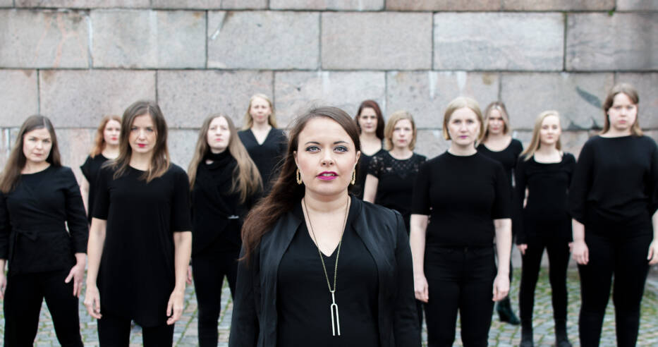 Kuvassa kaksitoista Sabrina ja Saarten tyttäret -laulukollektiivi jäsentä.