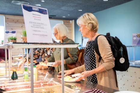 Elderly people taking food from the food line.