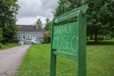 Kellokosken sairaalamuseon kyltti edustalla ja museorakennus taustalla